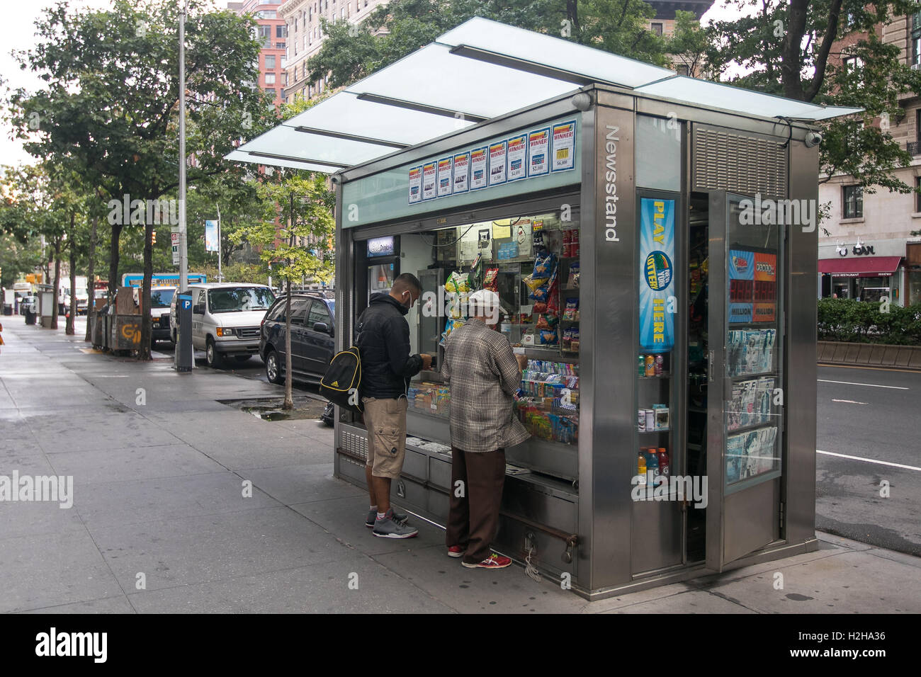 Two people are making purchases at a newsstand in Manhattan. Stock Photo