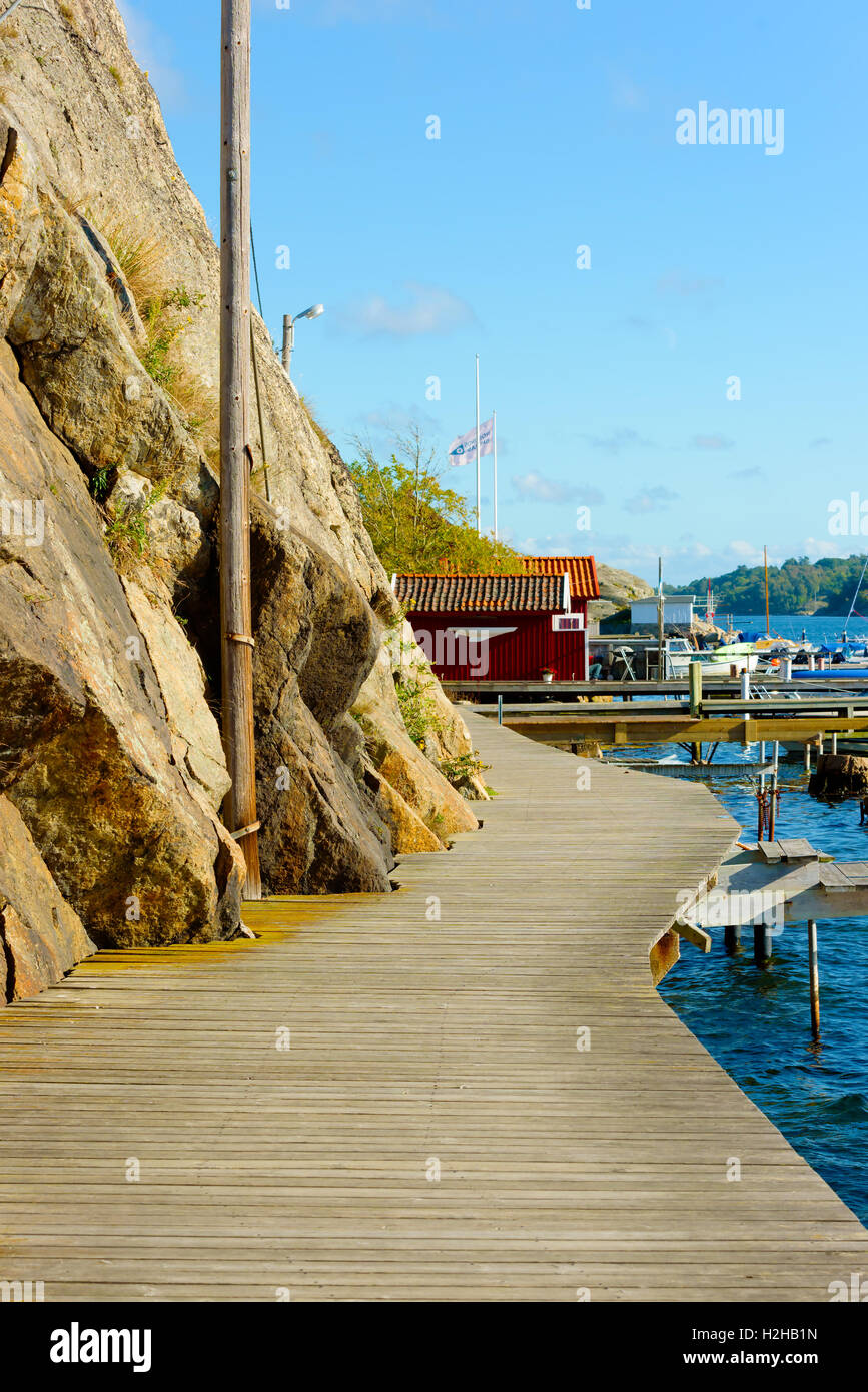Nosund, Sweden - September 9, 2016: Everyday documentary of the coastal promenade surrounded by steep cliff side and marina. Stock Photo