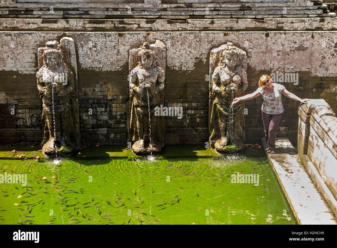 Indonesia, Bali, Goa Gajah, western tourist wearing trousers in bathing pool in C11th Hindu temple complex Stock Photo