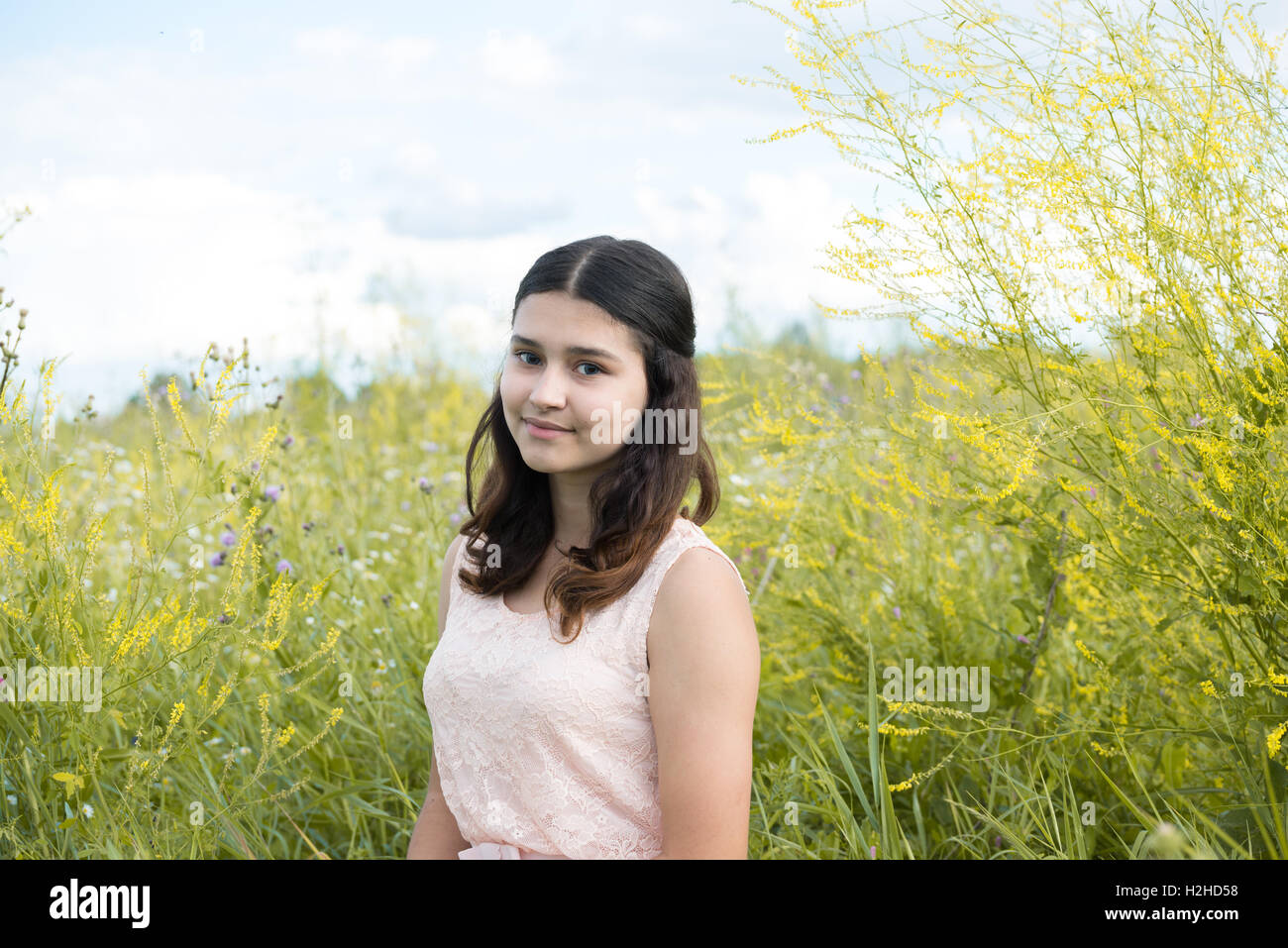 Girl in guipure dress resting on meadow Stock Photo