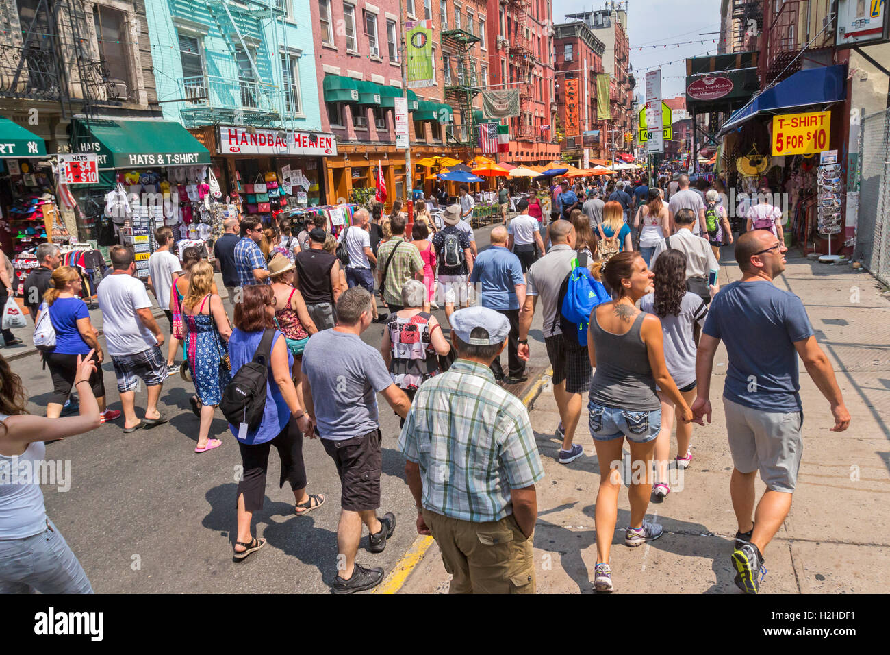 A tour guide travels with tourists walking in Little Italy, New York City. Stock Photo