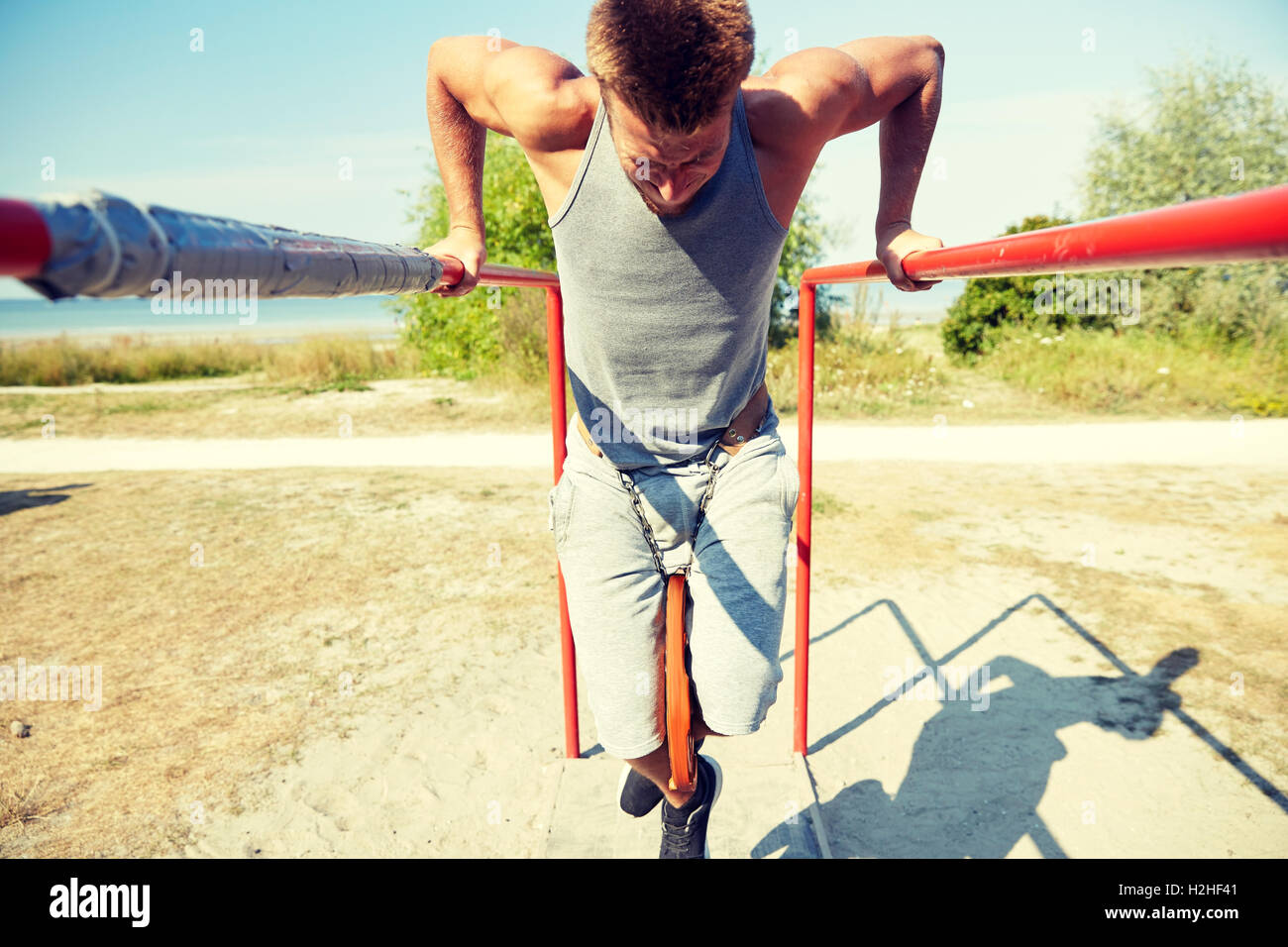 young man exercising on parallel bars outdoors Stock Photo - Alamy