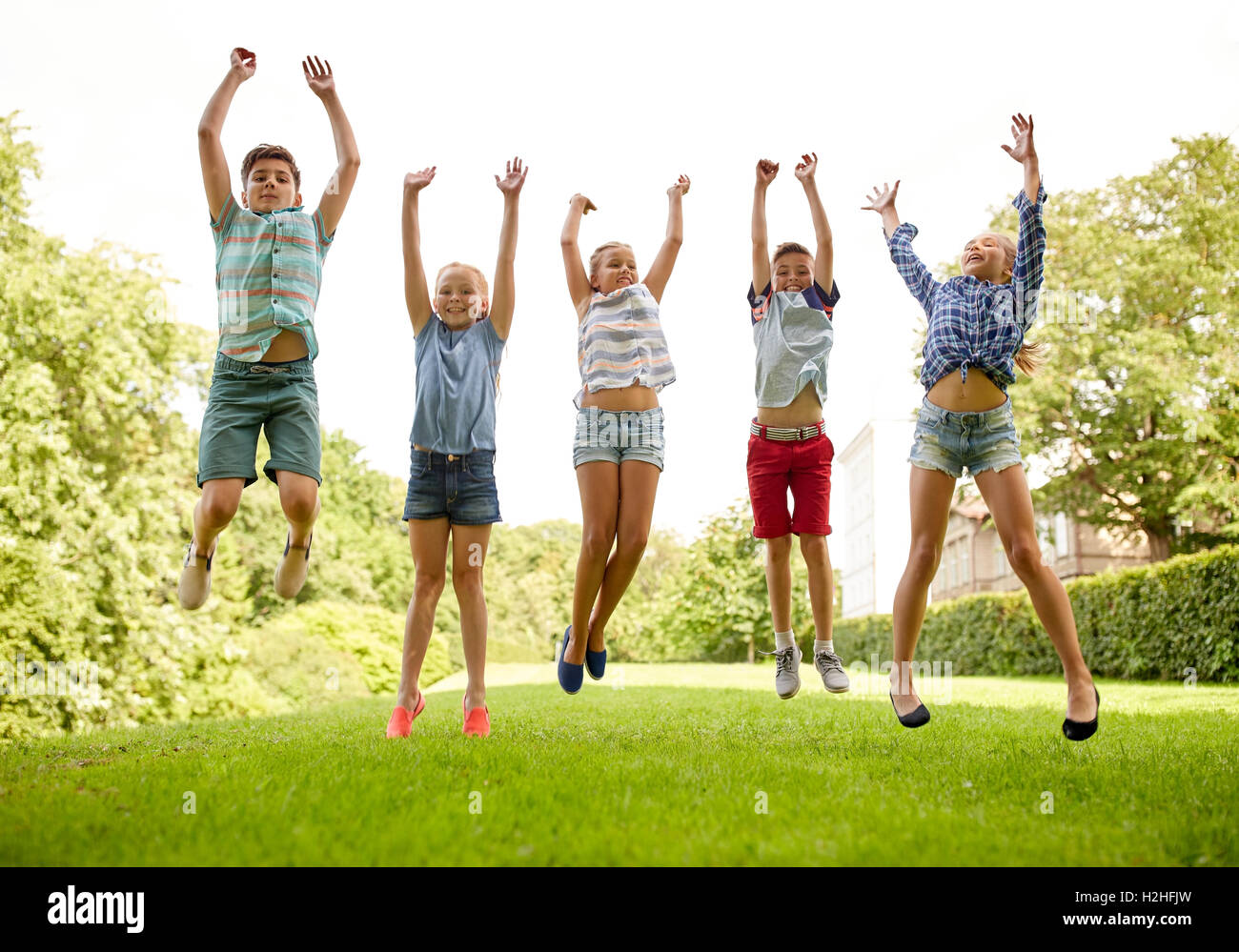 happy kids jumping and having fun in summer park Stock Photo
