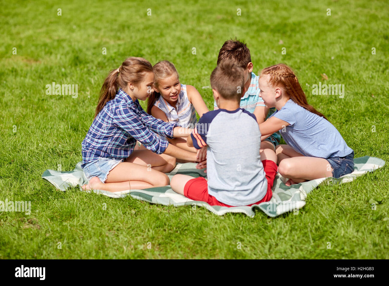 Group Of Happy Kids Putting Hands Together Stock Photo - Alamy