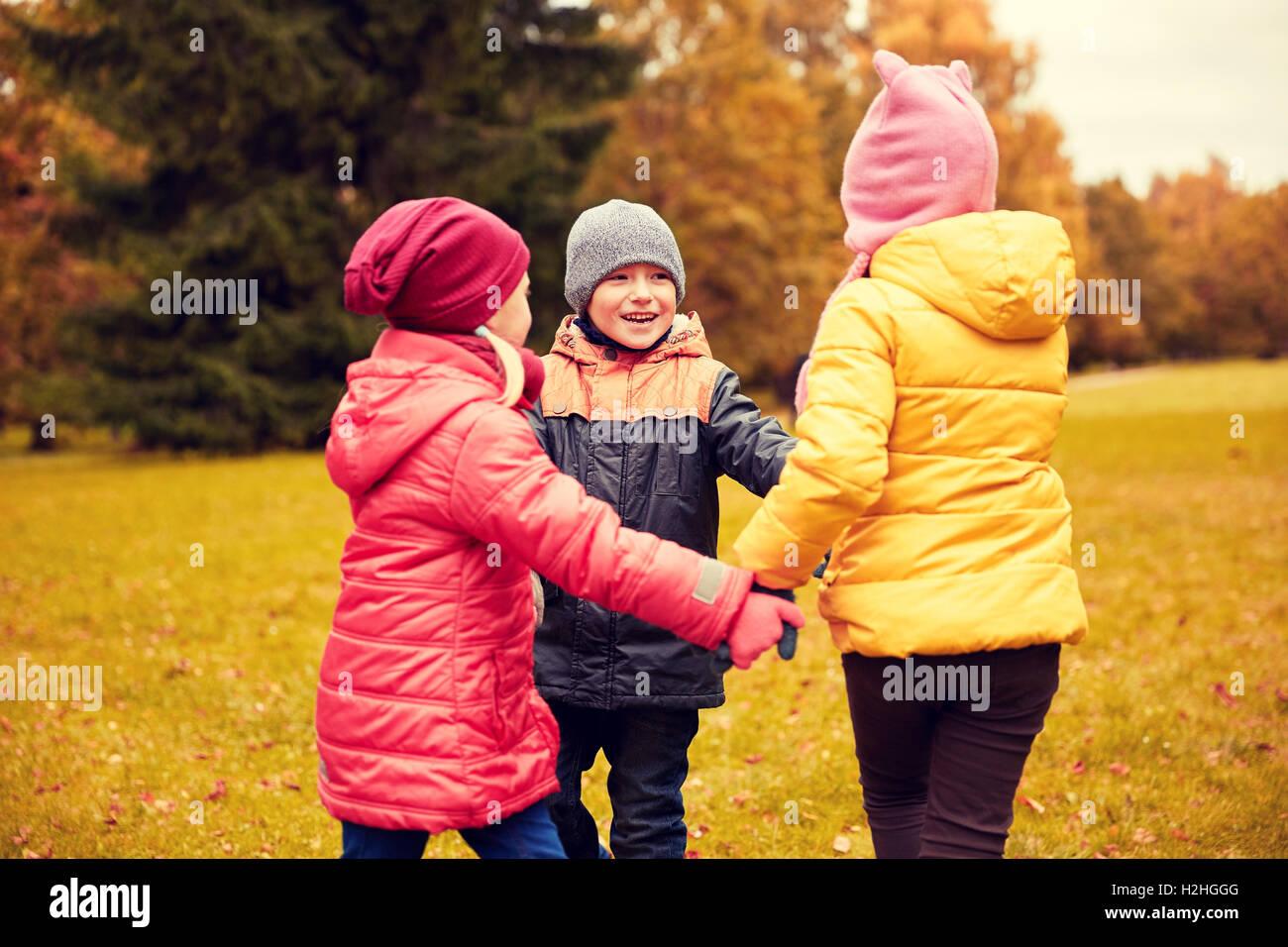 children holding hands and playing in autumn park Stock Photo - Alamy