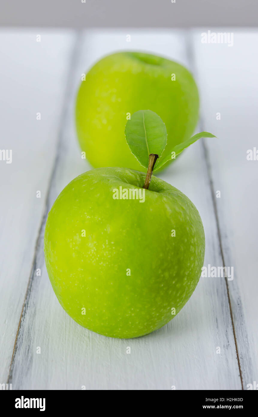 Ripe green apple with leaf  on a wooden background Stock Photo