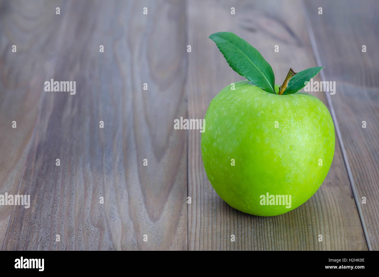 Ripe green apple with leaf  on a wooden background Stock Photo