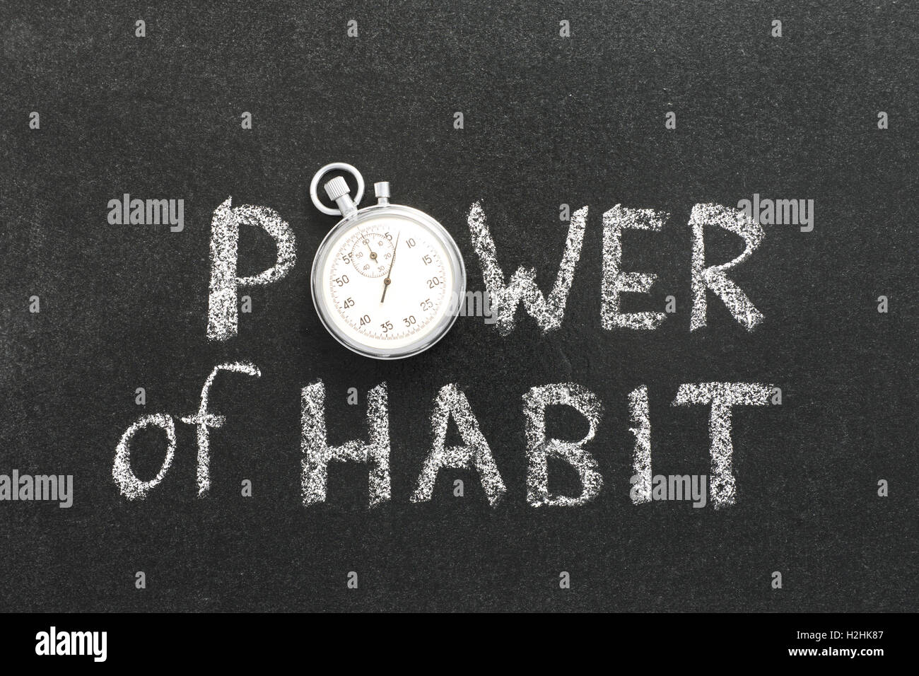 power of habit phrase handwritten on chalkboard with vintage precise stopwatch used instead of O Stock Photo