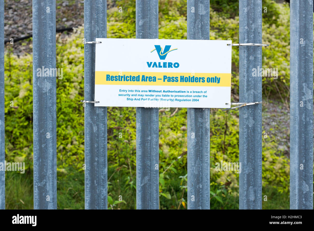 Sign saying 'Restricted area - pass holders only' on metal fencing at Valero oil storage facilities in Pembroke Stock Photo
