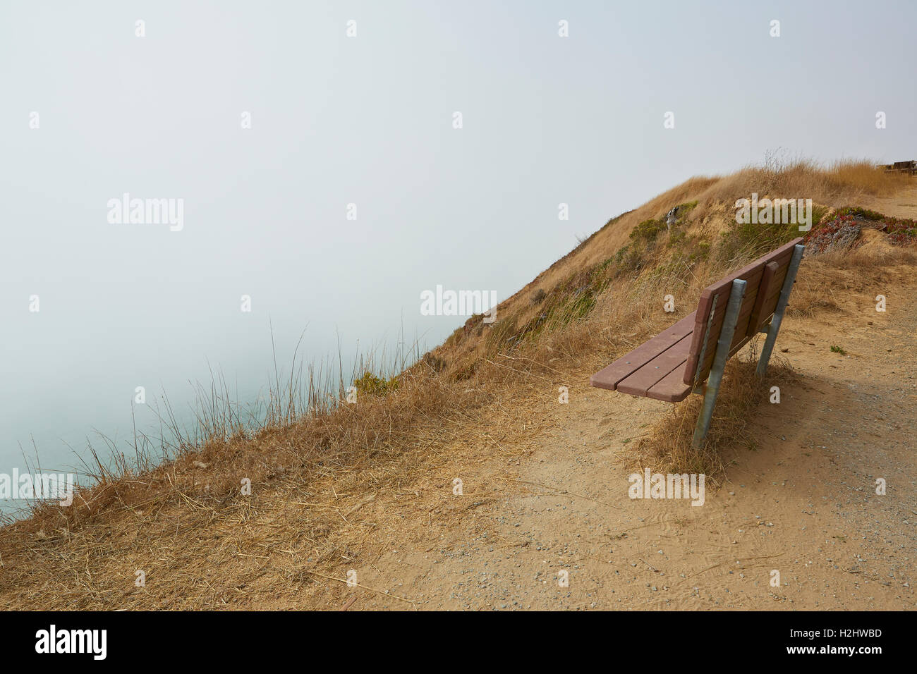 Park Bench Above A Cliff With Sea Fog Rolling In, Angel Island, California. Stock Photo