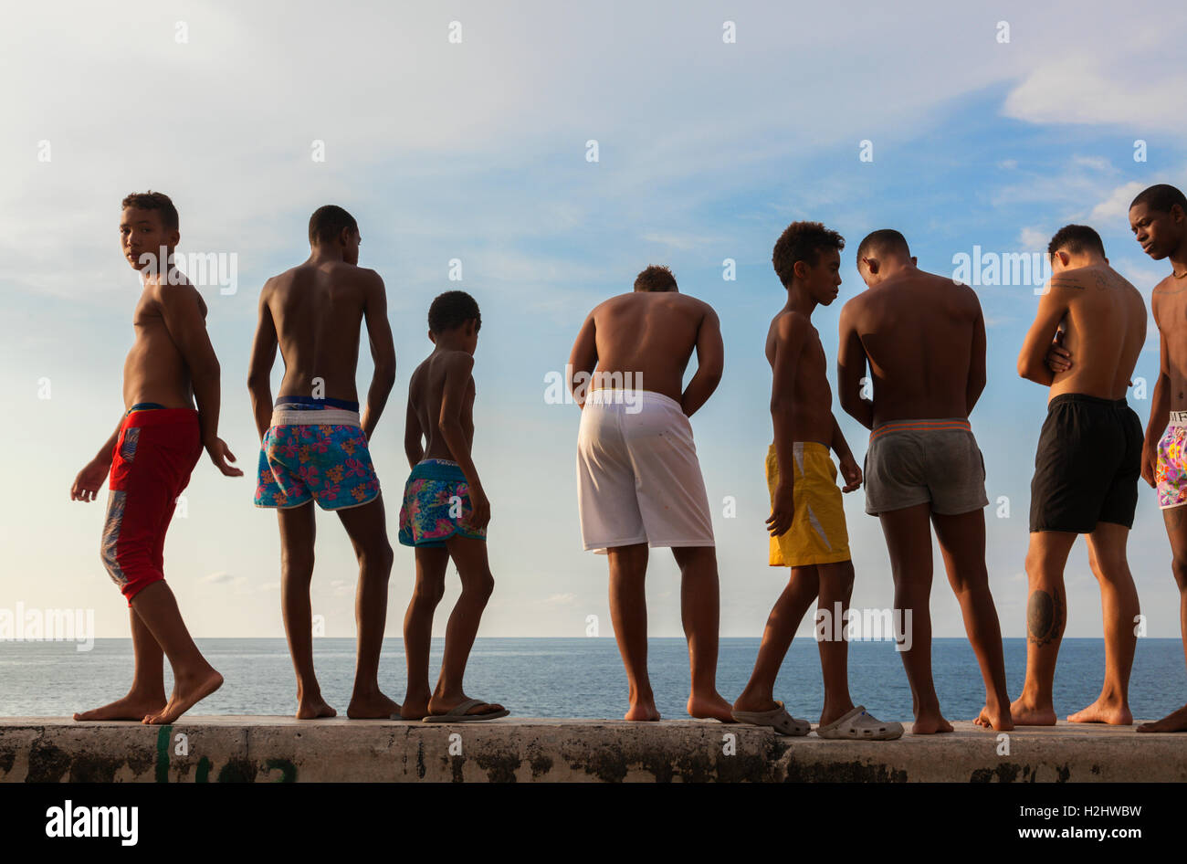 Kids in their bathing suits standing along the seawall about to go swimming along the Malecón in Central Havana, Cuba. Stock Photo