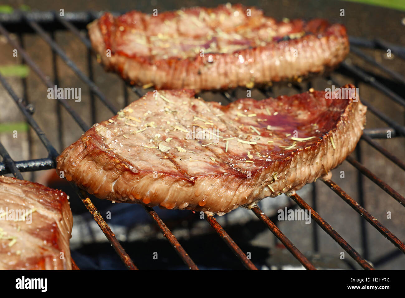 Grilled sizzling beef barbecue steaks with spices cooking prepared on