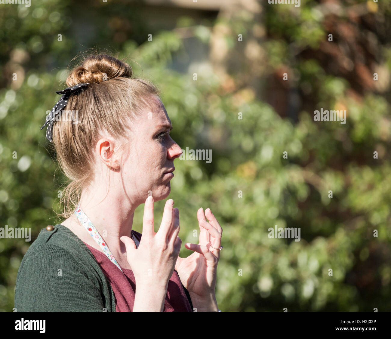 Female signer using sign language for people with impaired hearing at UK festival Stock Photo