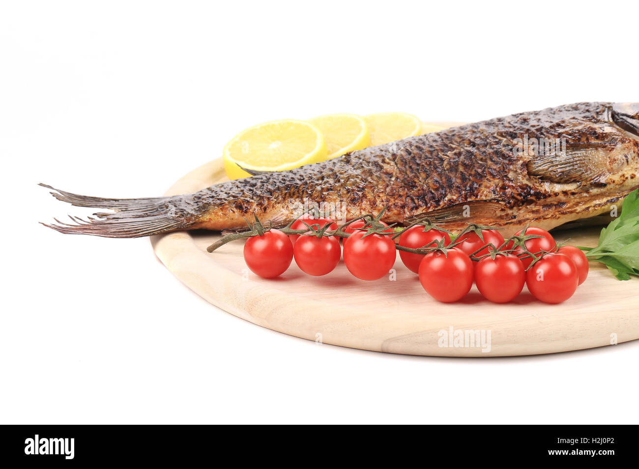Grilled carp fish with tomatoes. Stock Photo