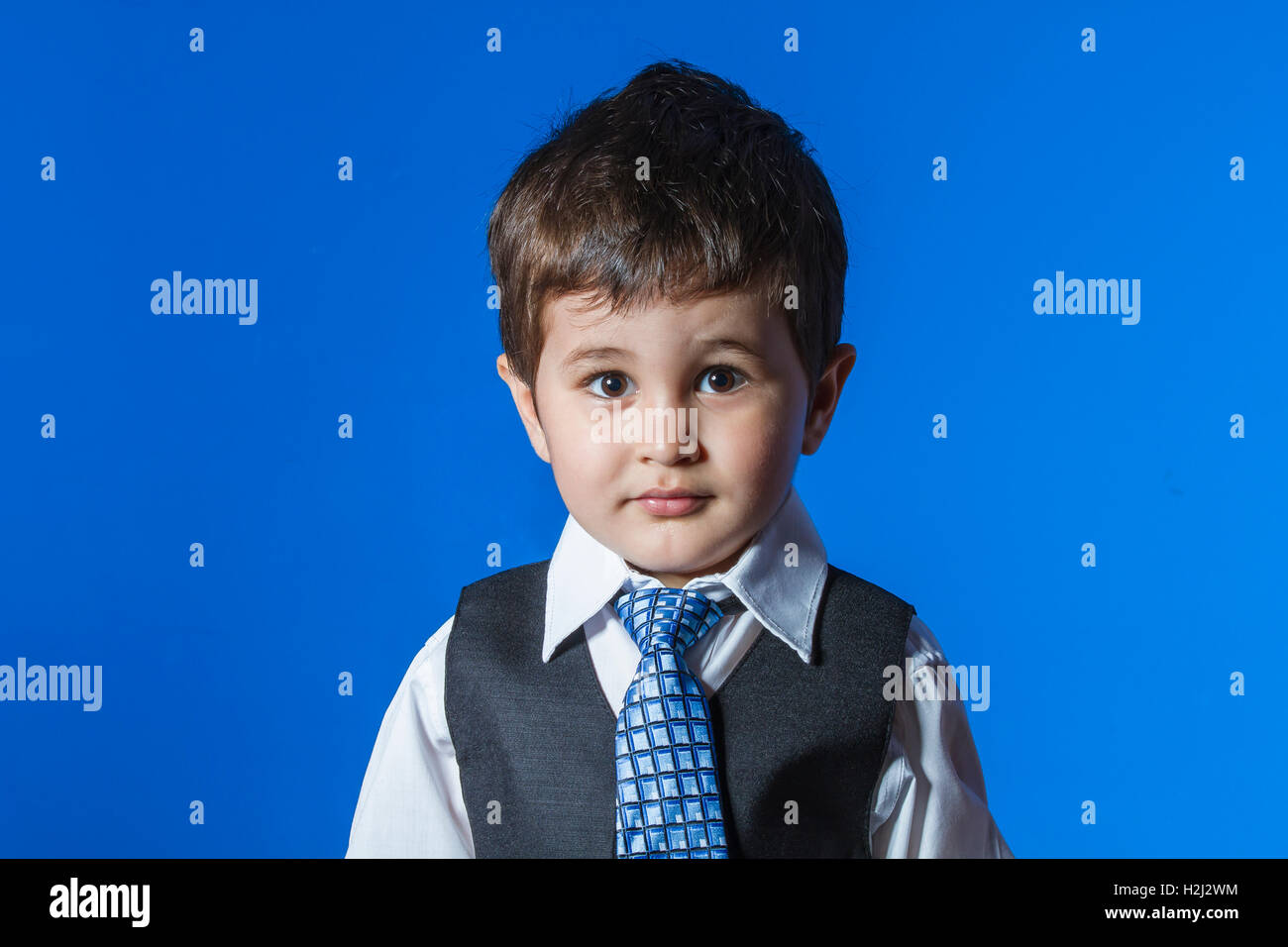 Leader, cute little boy portrait over blue chroma background Stock