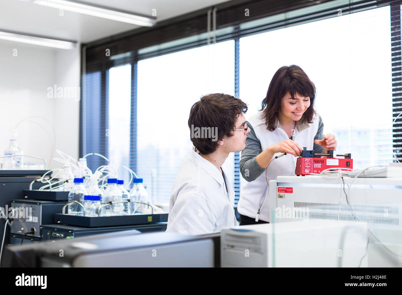 Two young researchers carrying out experiments in a lab Stock Photo