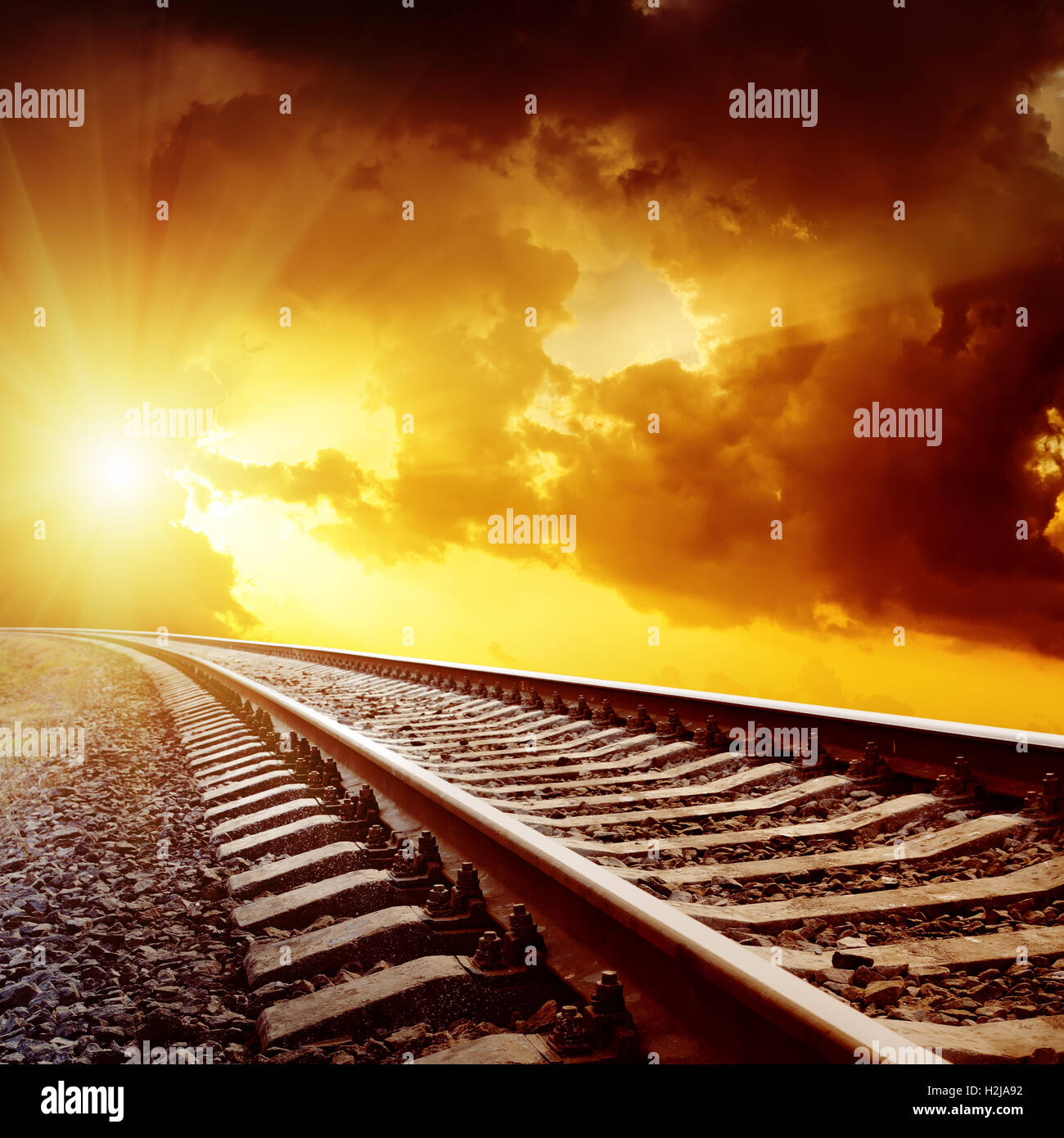sunset with dark clouds over railroad Stock Photo - Alamy