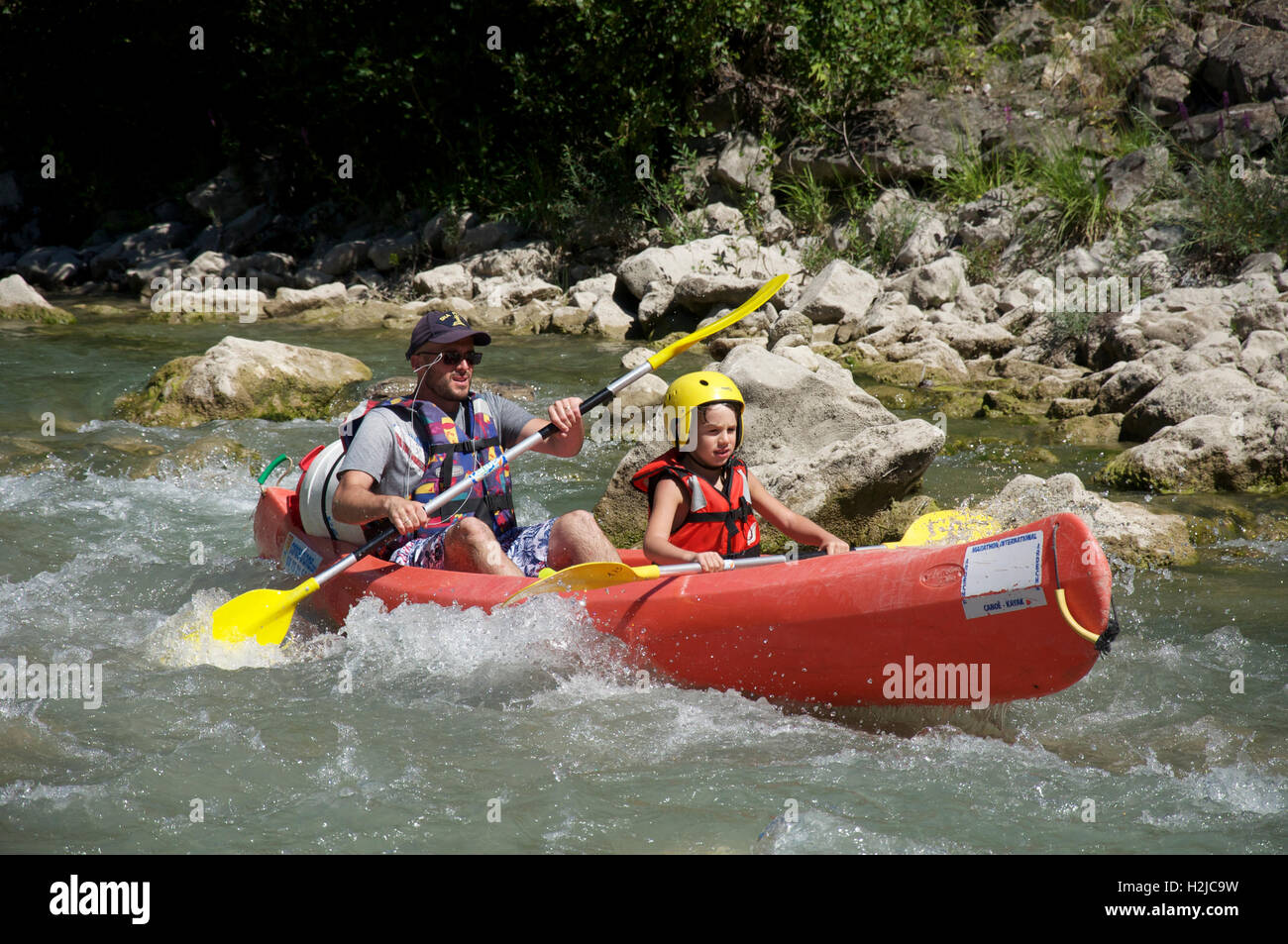 Tourism, water-sports. A father and his young son canoeing down the turbulent fast flowing waters of the Drôme River. Near Saillans, La Drôme, France. Stock Photo