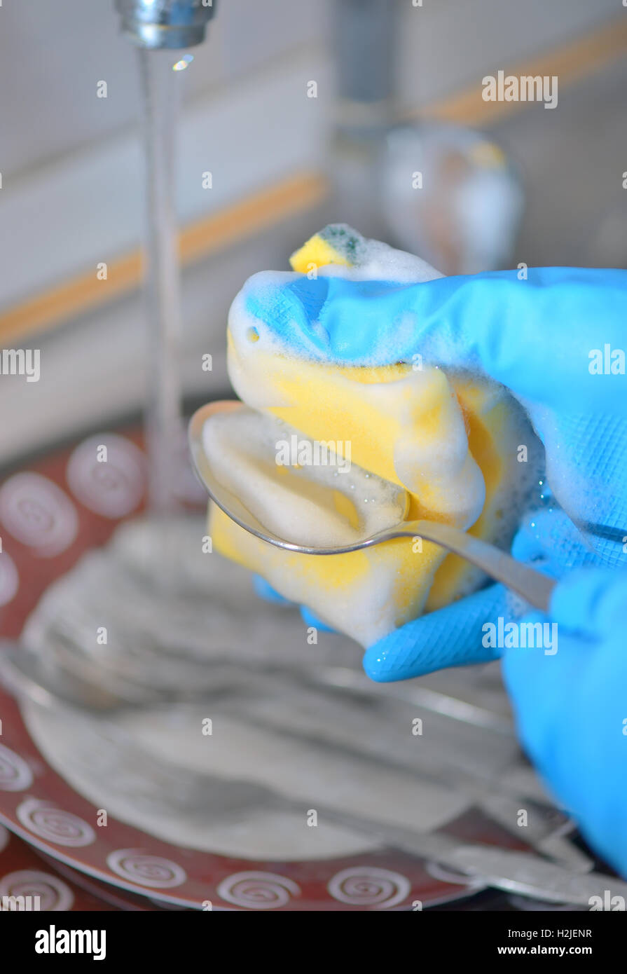 Woman hand washing dishes in the kitchen Stock Photo