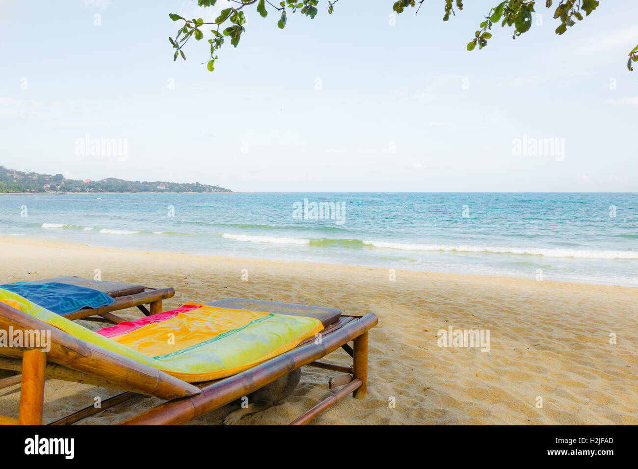 Two empty loungers with towels on a beautiful bounty beach in Thailand Stock Photo