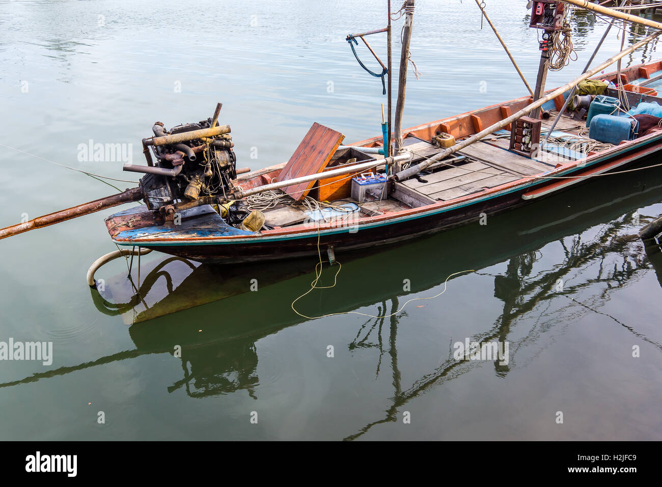Old thai fishing boat with fishing equipment and a big outboard motor at  anchor in the port Stock Photo - Alamy