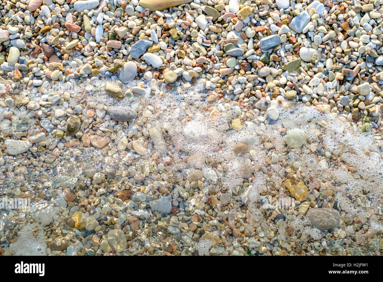 Pebbly beach and little wave background Stock Photo