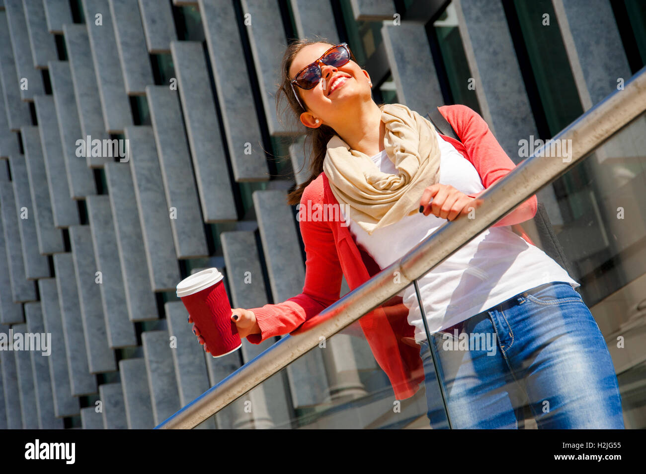 Caucasian woman Vivacious in City with a beautiful beaming smile backlit by the warm glow of the sun shining down City. Stock Photo