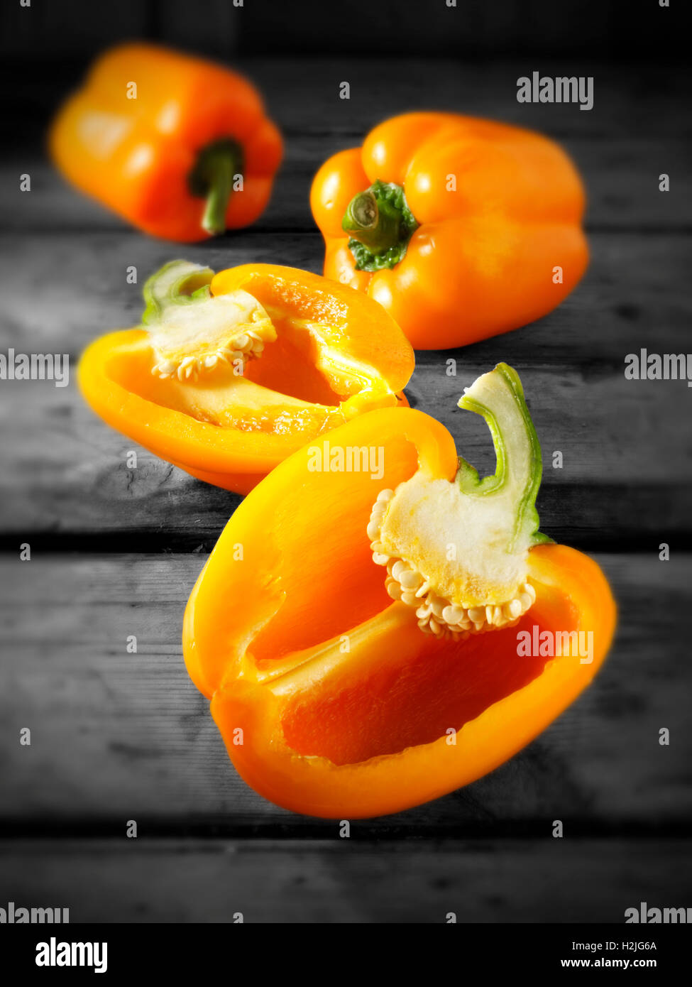 Fresh orange bell peppers whole and cut Stock Photo