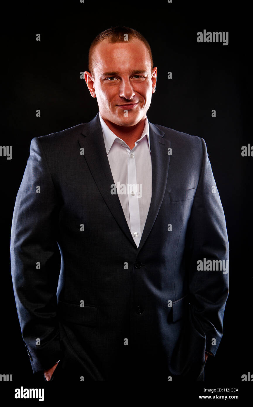 Man in suit smiling over dark background Stock Photo - Alamy