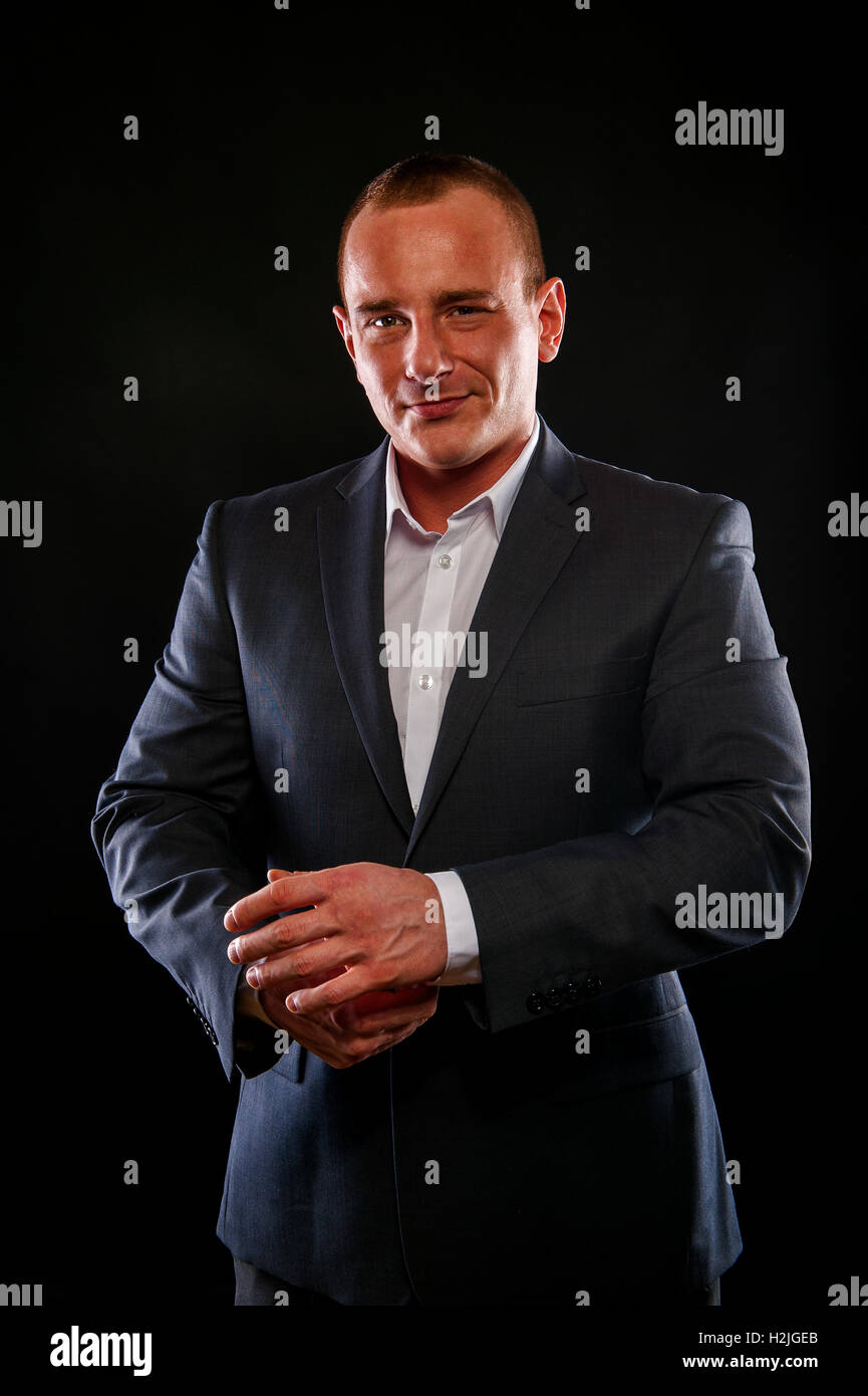 Man in suit smiling over dark background Stock Photo - Alamy