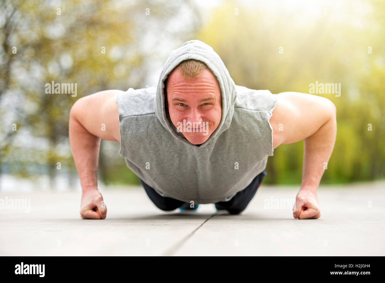 Active man doing push up in park Stock Photo - Alamy