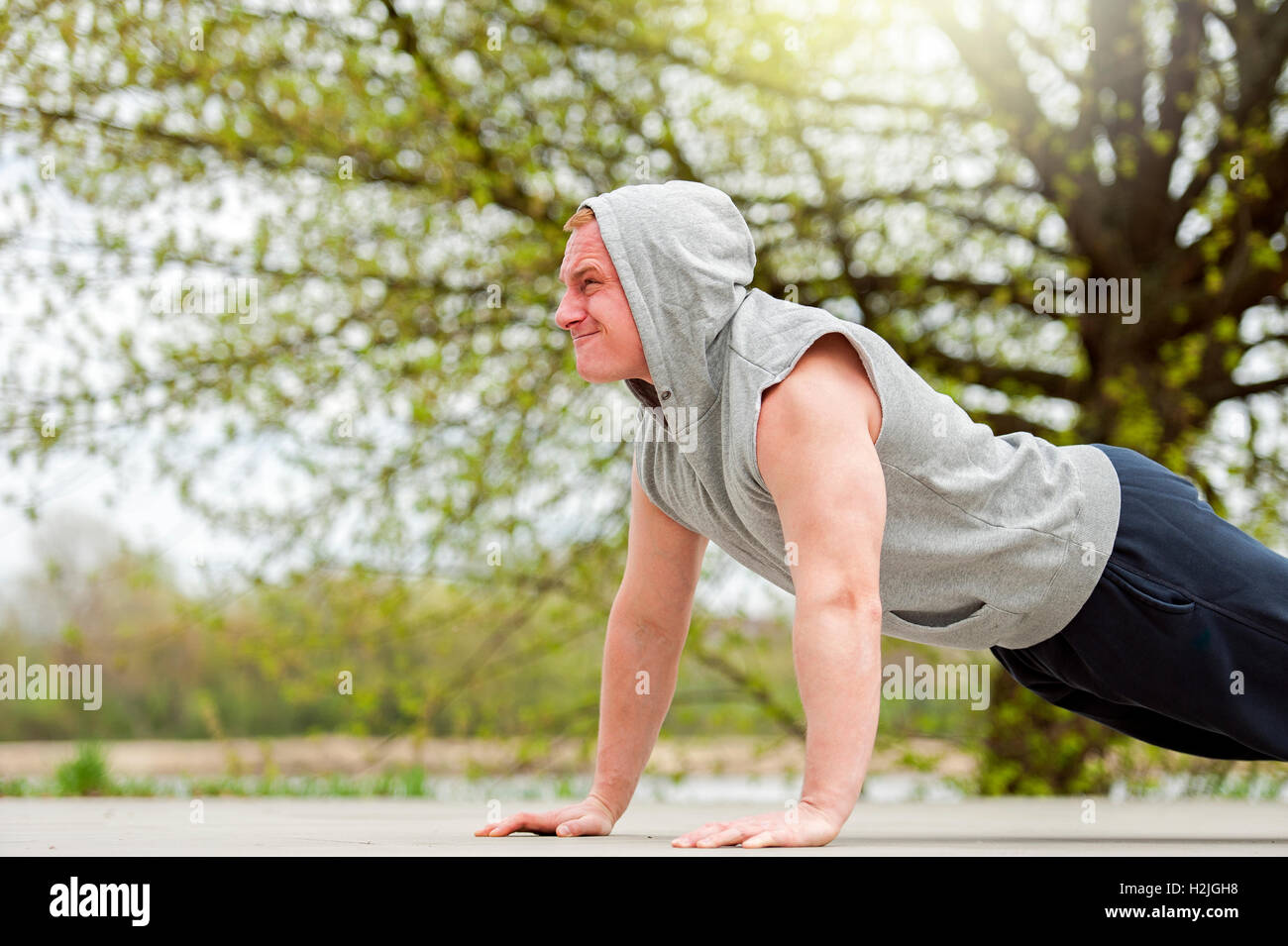 Active man doing push up in park Stock Photo - Alamy