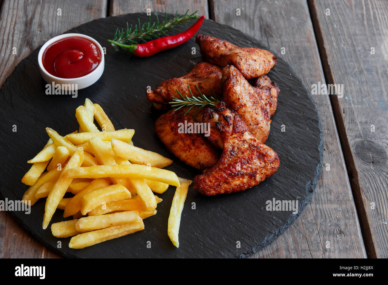 Fried roasted chicken wings french fries and sauce Stock Photo