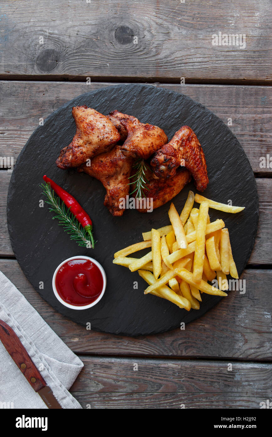 Fried roasted chicken wings french fries and sauce Stock Photo
