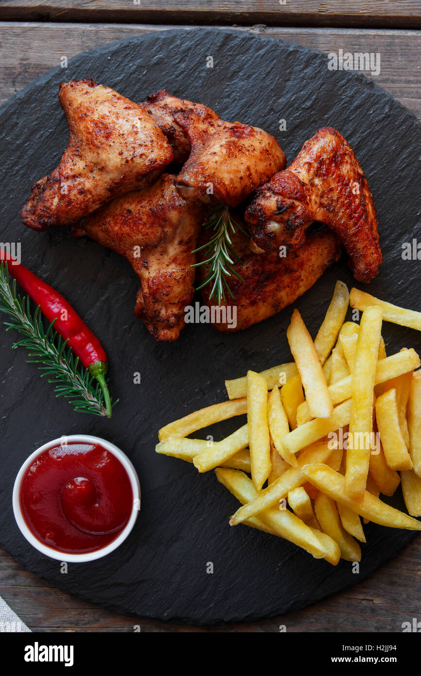 Fried roasted chicken wings french fries and sauce Stock Photo