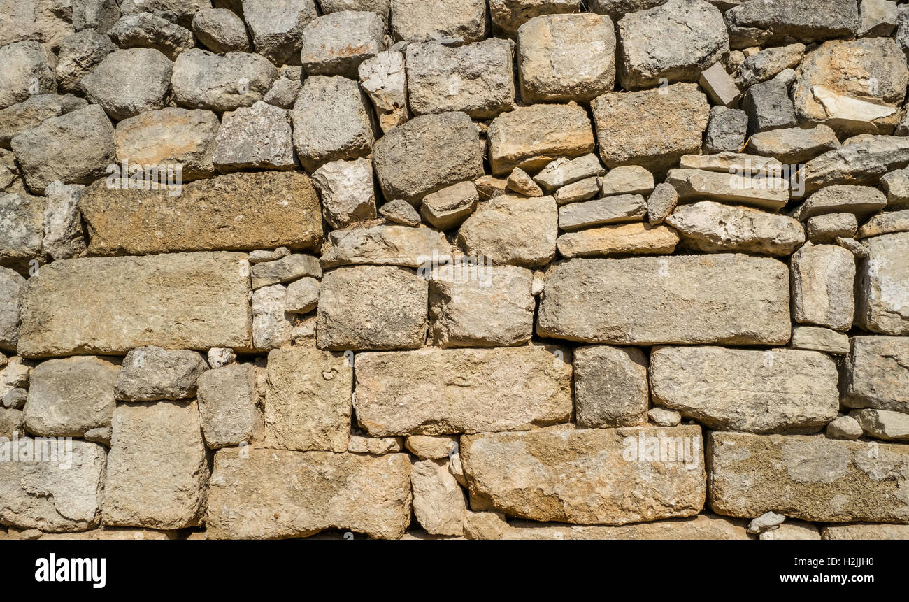Traditional wall of stones built without lime. Dry stone wall. Stock Photo