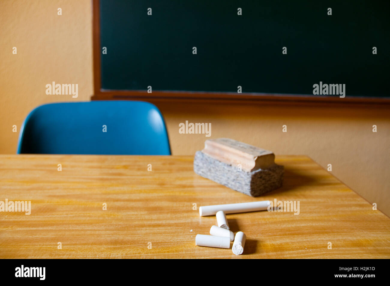 Chalks and board duster on teacher's table. Stock Photo