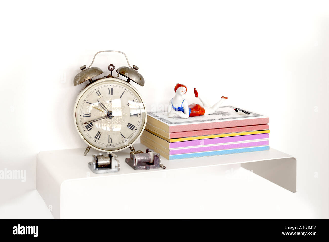 Alarm clock and books on nightstand Stock Photo
