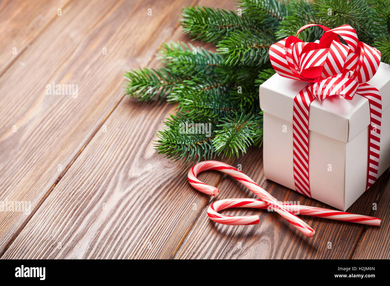 Christmas gift box, candy cane and fir tree branch. View with copy ...