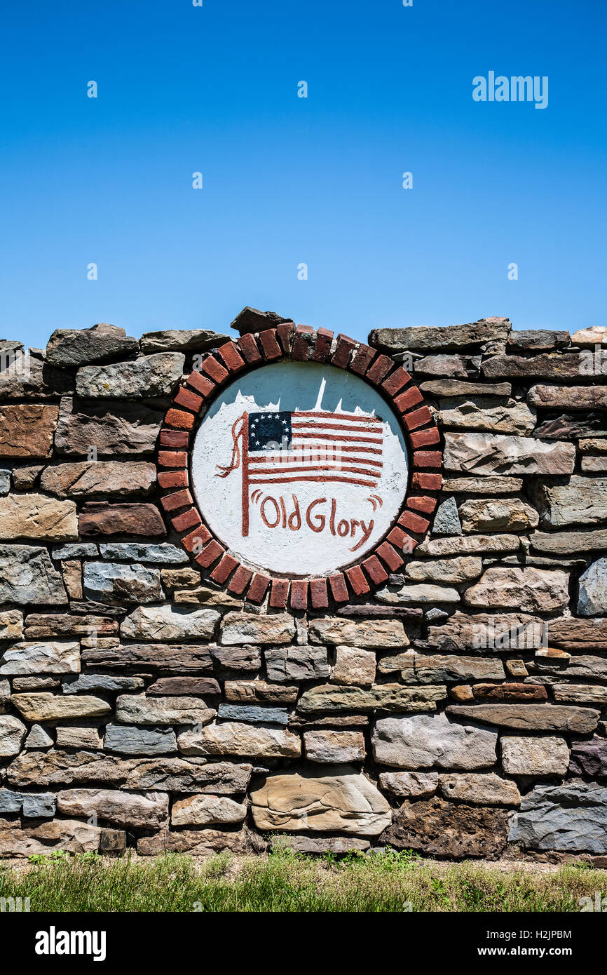 Hand painted American flag with old glory on old stone barn foundation wall and blue sky, New Jersey, USA, rural America vertical farming pt Stock Photo