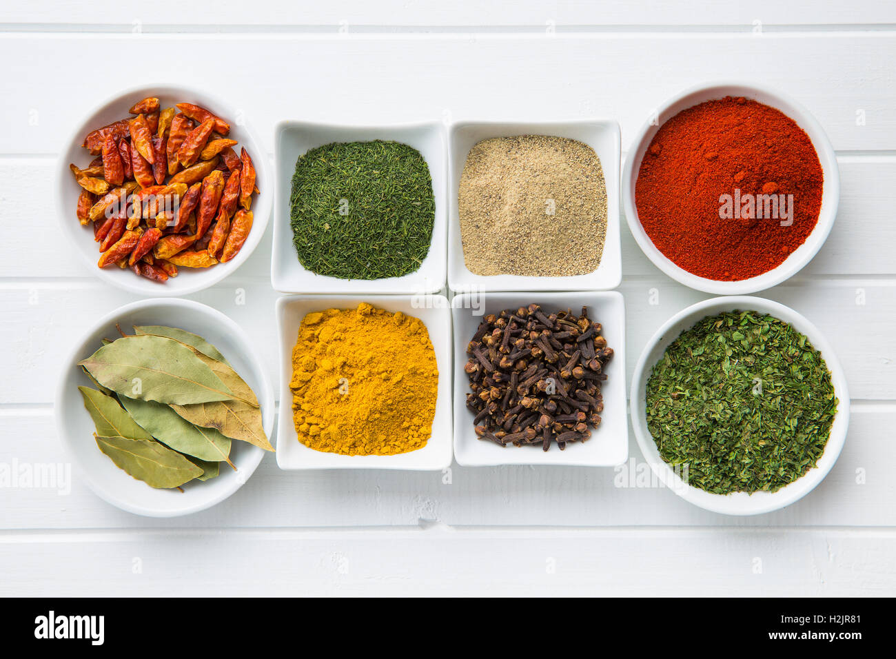 Various dried herbs and spices in bowl on white kitchen table Stock ...