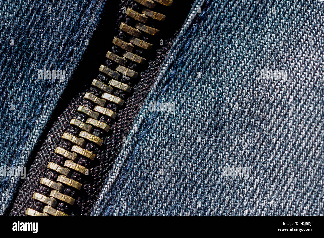 Close up and detailed shot of a metallic zip on denim Stock Photo