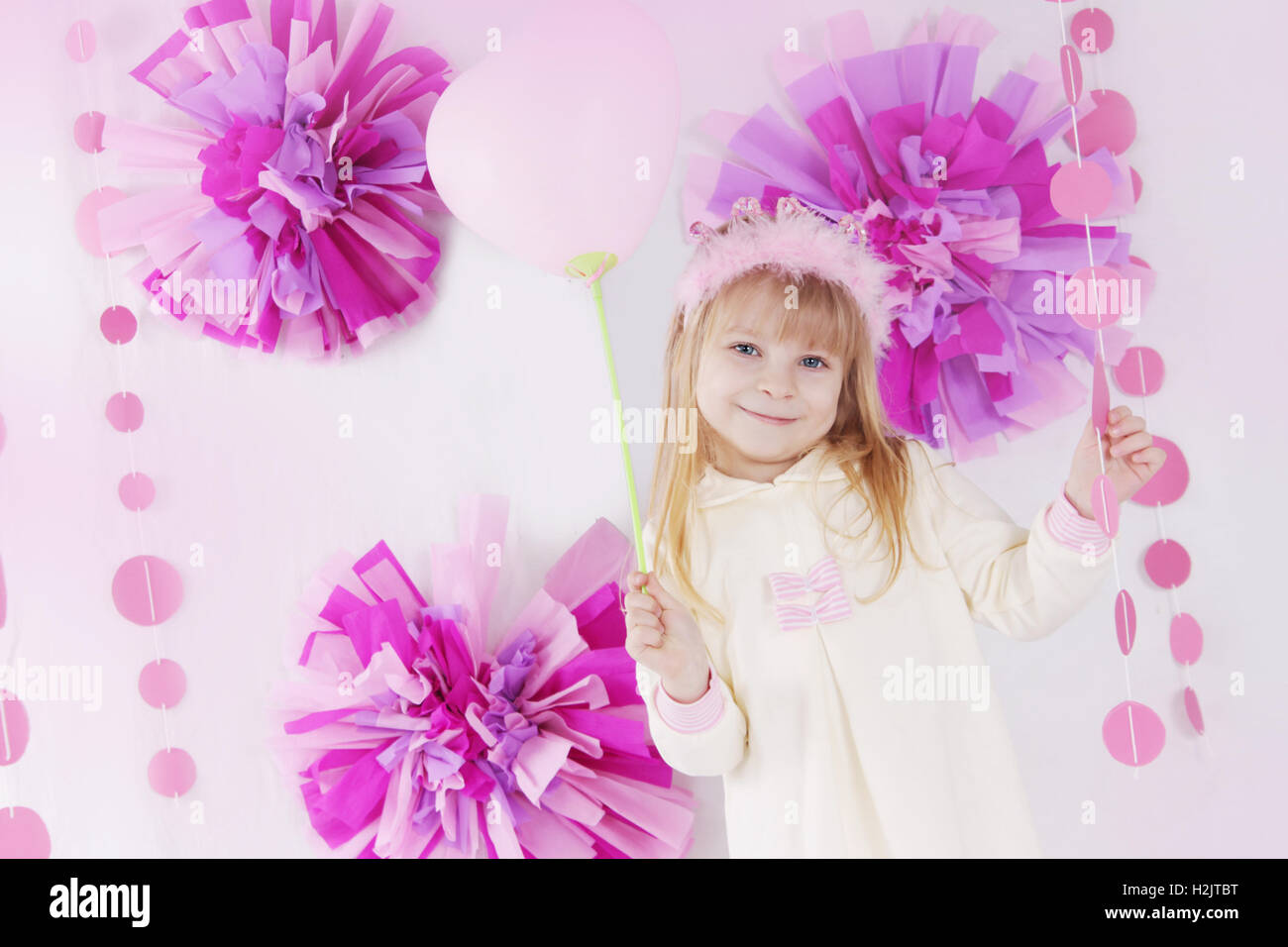 Little girl at pink decorated birthday party with balloon Stock Photo