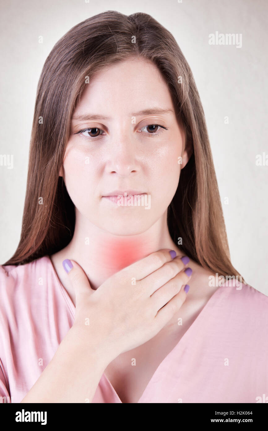 Woman with a sore throat holding her neck Stock Photo