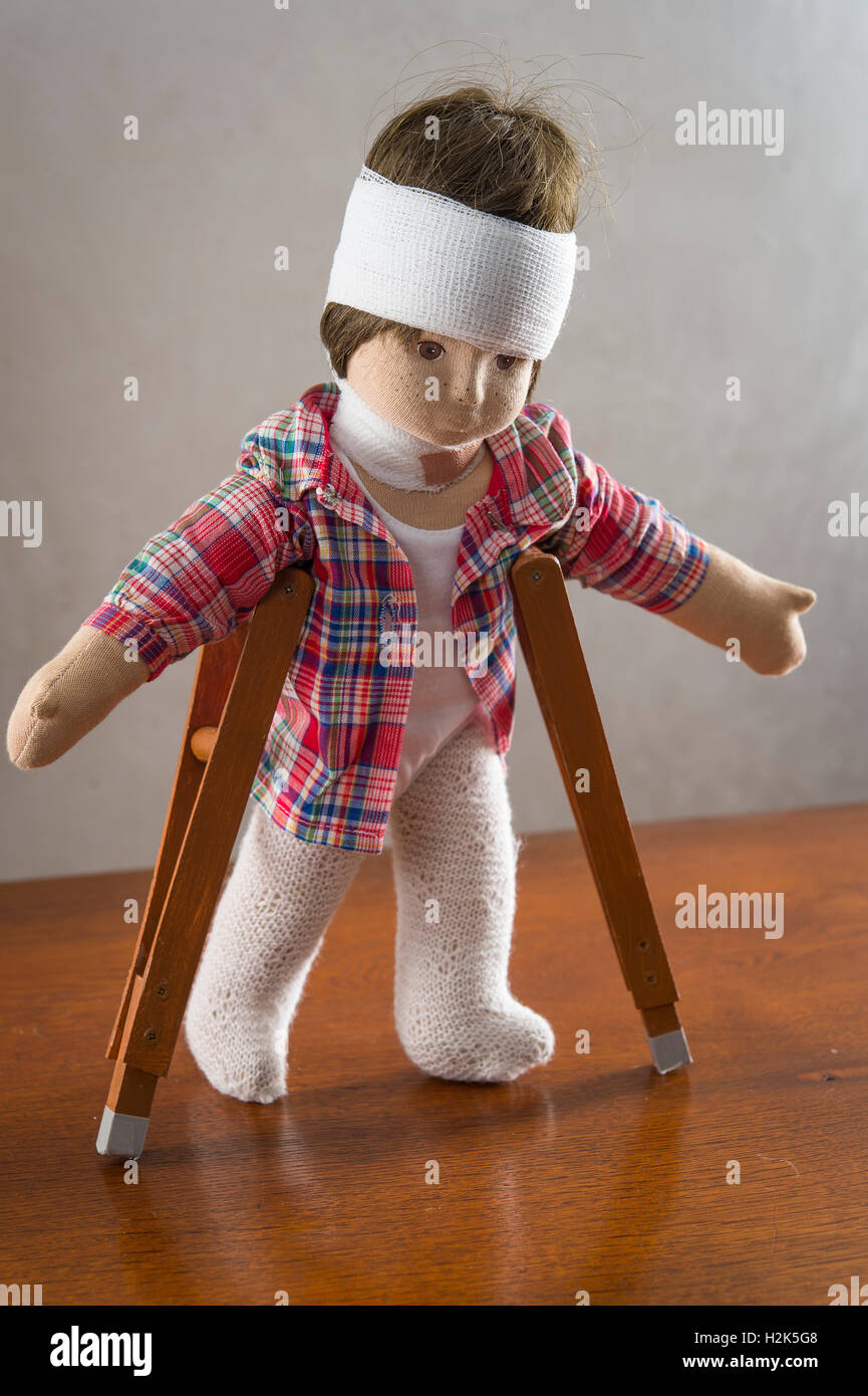Doll with bandage on head, neck brace, crutches, walking Stock Photo