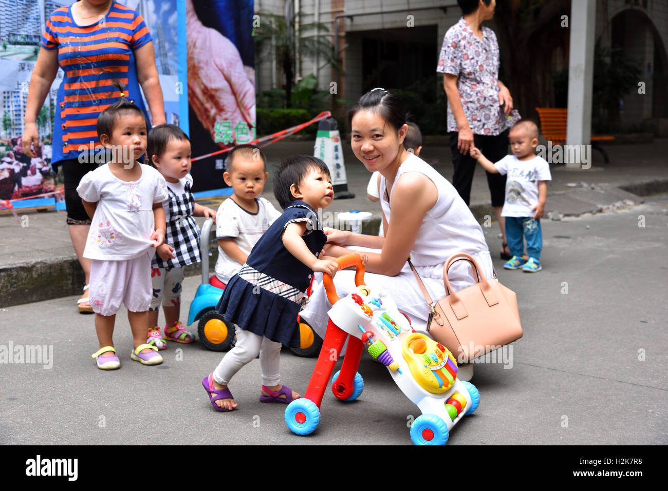 Group of Chinese children and their mums with kids having fun. Stock Photo