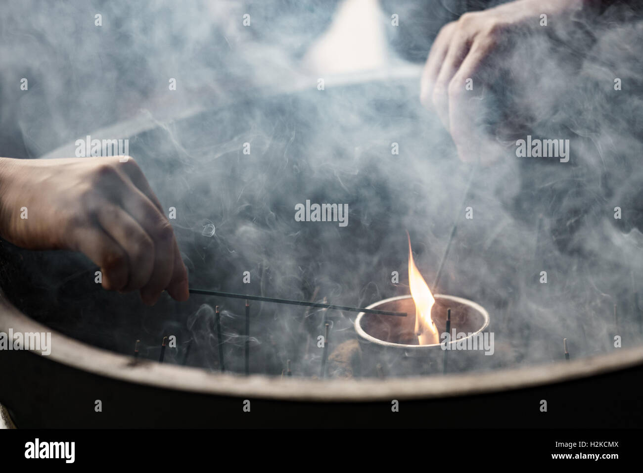 Hands light incense sticks hi-res stock photography and images - Alamy