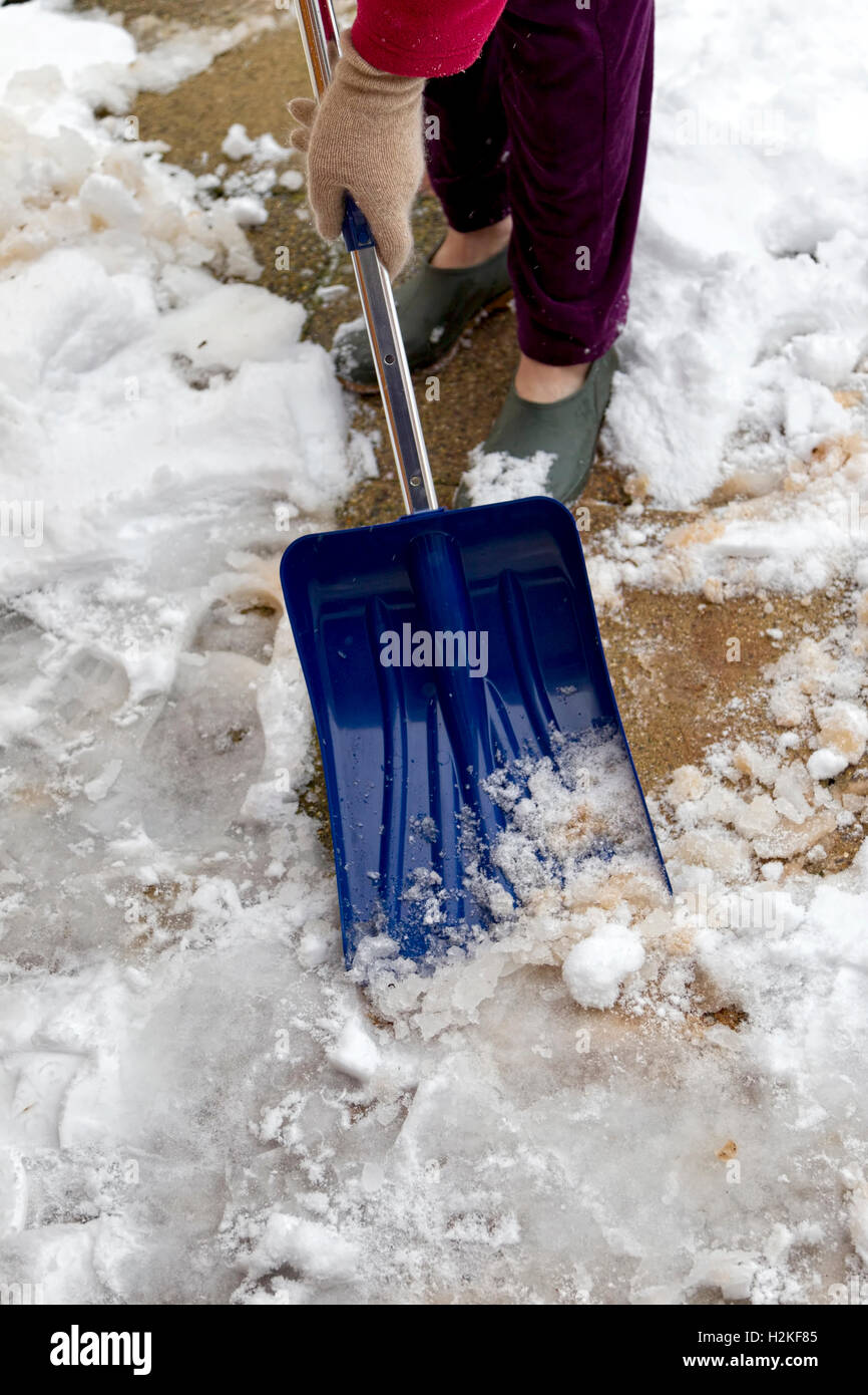 Woman using a snow shovel hires stock photography and images Alamy