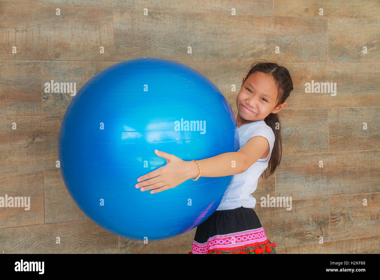 Girl child holding blue big rubber ball. Stock Photo