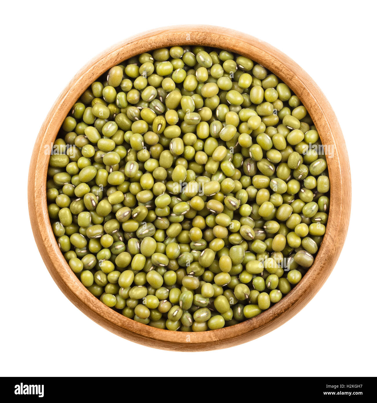 Mung beans in a wooden bowl on white background. Dried beans of Vigna radiata, also moong bean, green gram or mung, a legume. Stock Photo